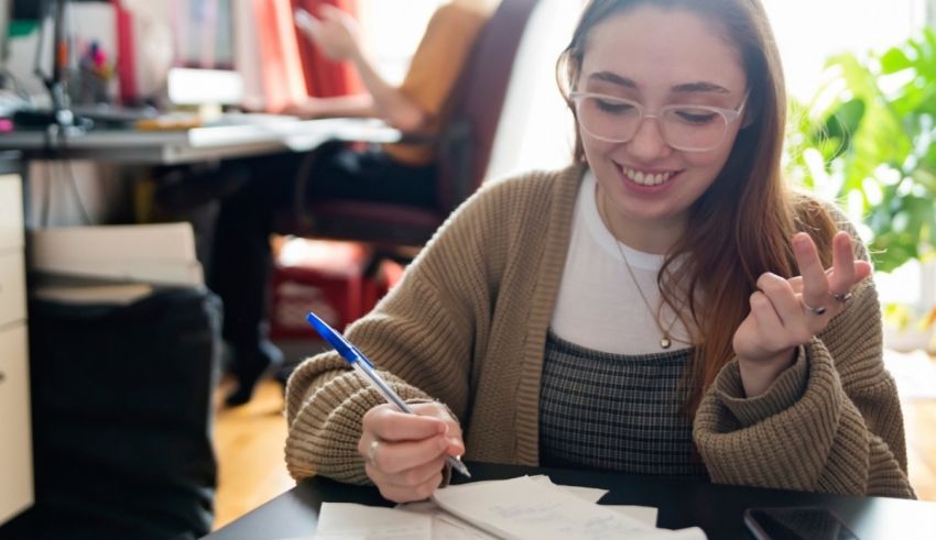 A young woman writing on a piece of paper.