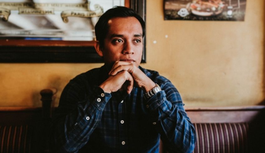 A man sitting at a table with his hand on his chin.