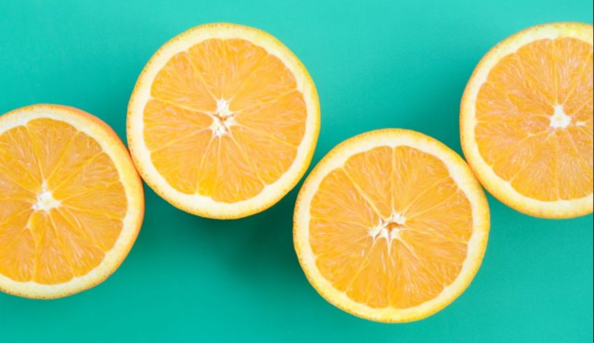 Four orange slices on a green background.