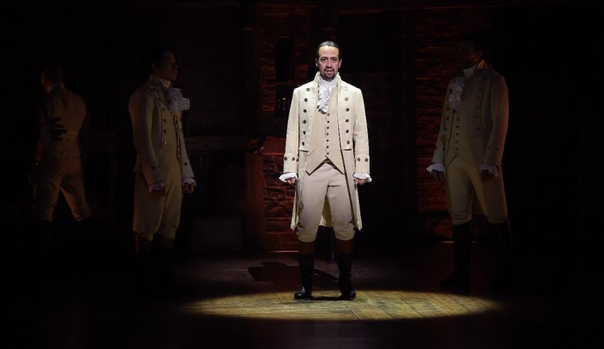 A group of men dressed in white standing in front of a light.