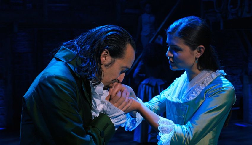 A man and woman in a green dress are touching each other's hands.