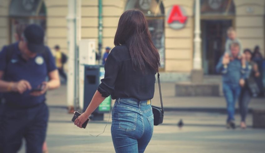 A woman in jeans walking down the street.