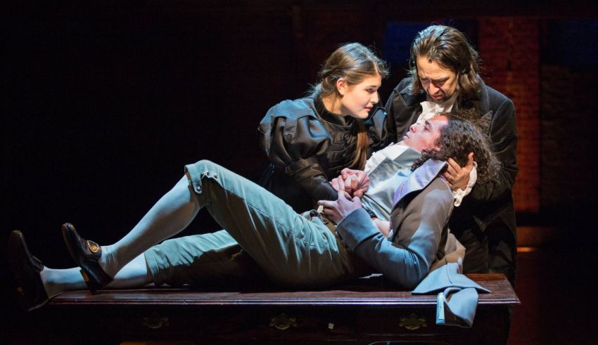 Three people are laying down on a wooden table.