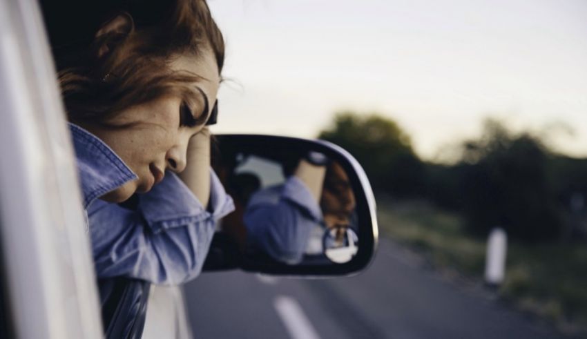 A woman looking out the window of a car.
