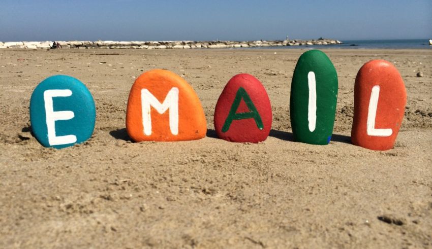 The word email is spelled out in colored rocks on the beach.