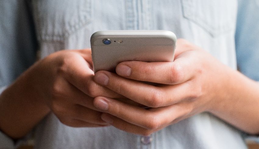 A woman's hands holding a cell phone.