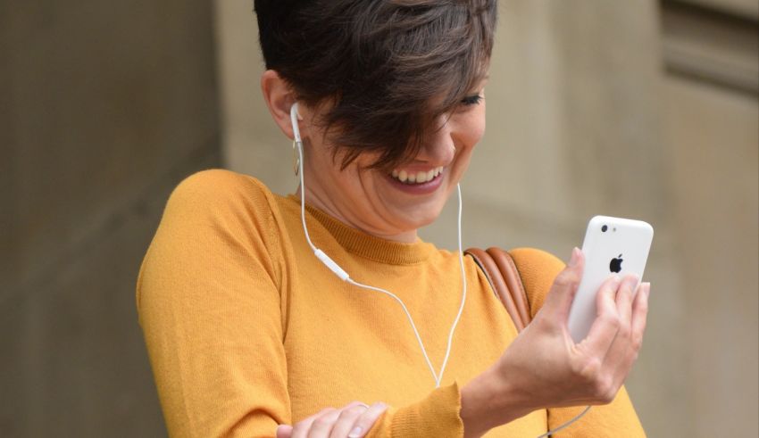 A woman is listening to music on her cell phone.