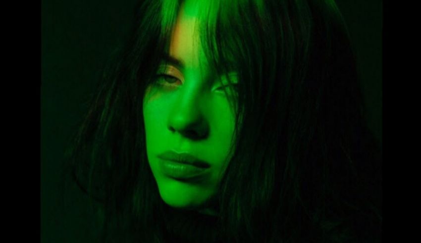 A woman with long hair and green paint on her face.