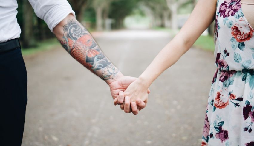 A man and woman holding hands on a road.