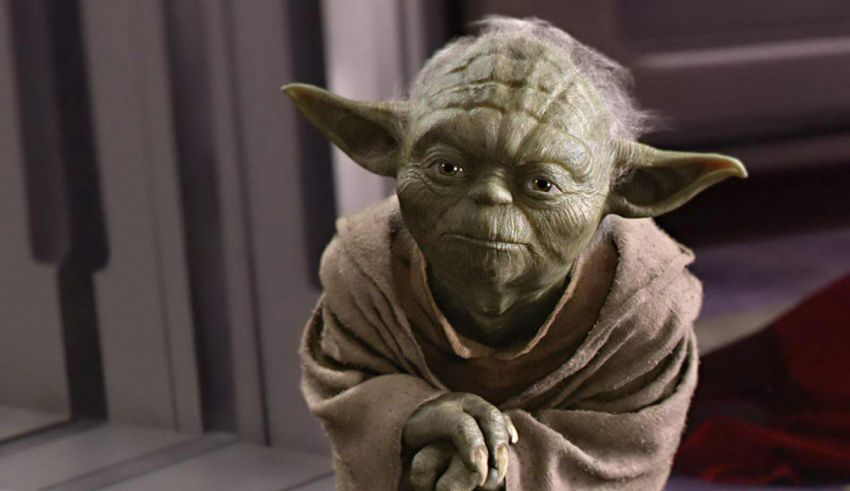 Yoda is sitting on a chair in front of a door.