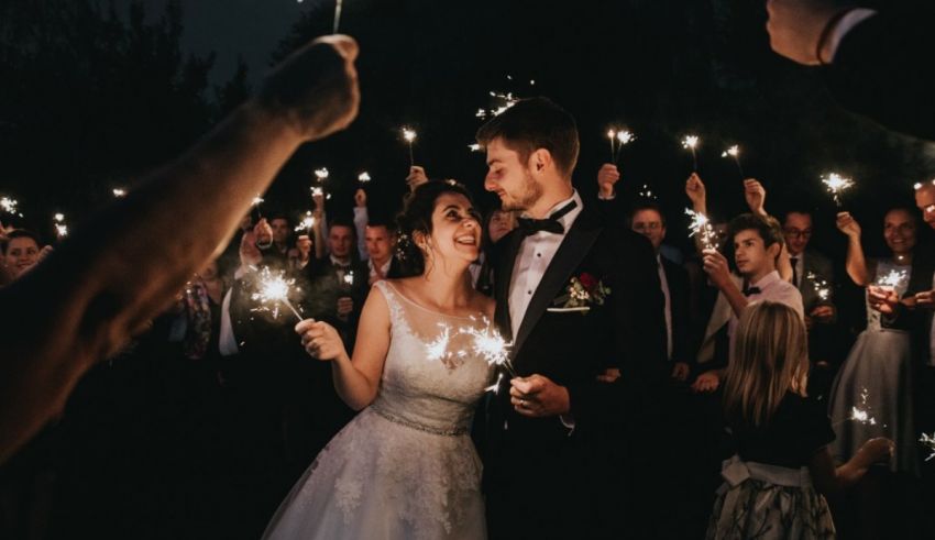 A bride and groom holding sparklers at their wedding reception.