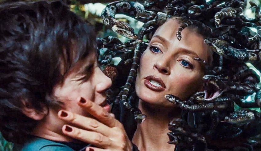 A woman with a snake on her head is being kissed by another woman.