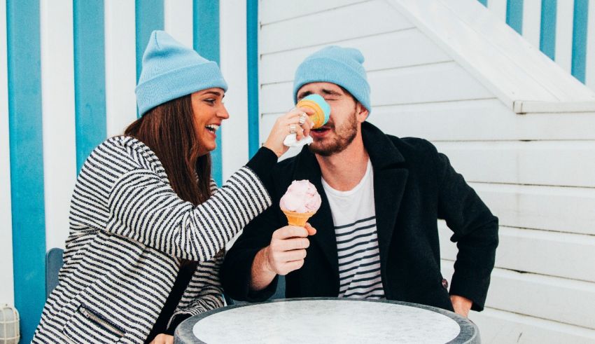 A man and woman eating ice cream at a table.