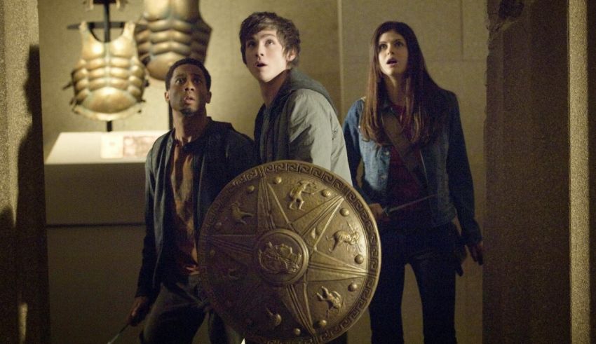 A group of people standing in a dark room with a shield.