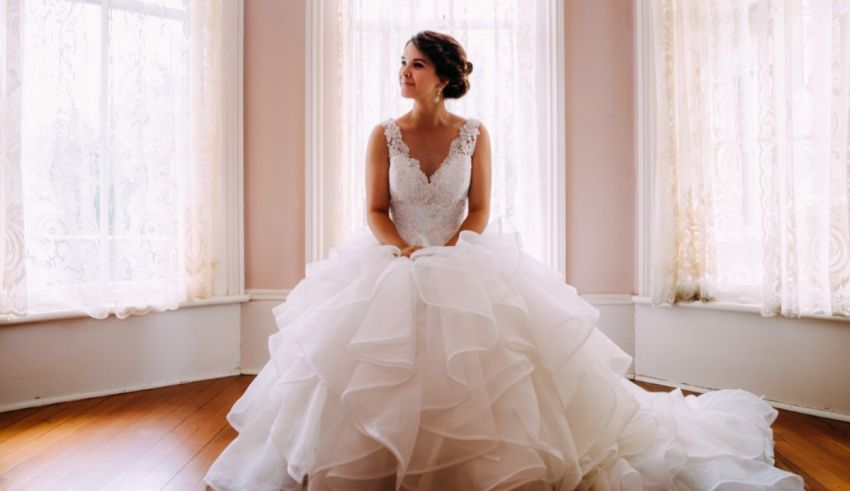 A bride in a wedding dress sitting in a room.