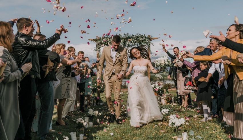 A bride and groom walk down the aisle with confetti thrown at them.