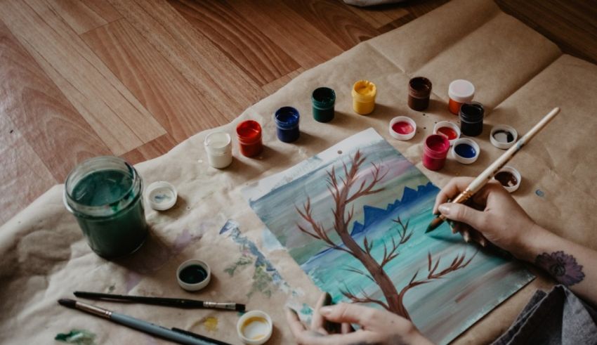 A woman paints a tree on a piece of paper.