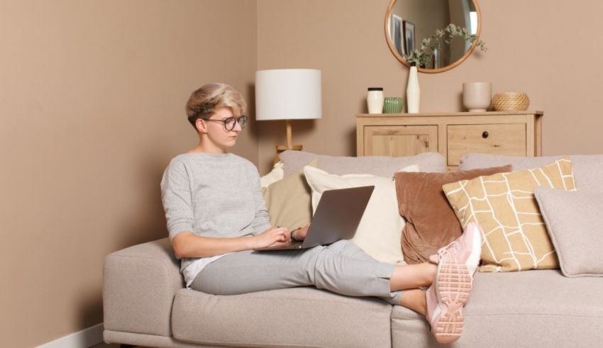 A woman sitting on a couch using a laptop.