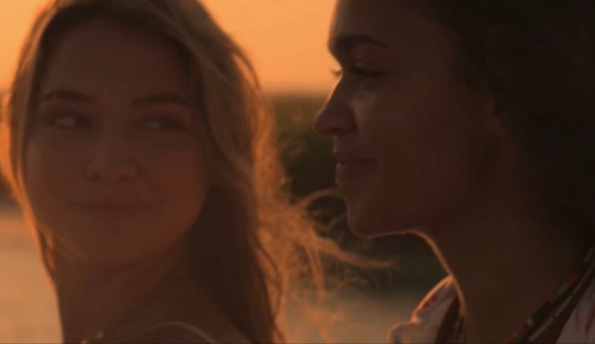 Two young women looking at each other at sunset.