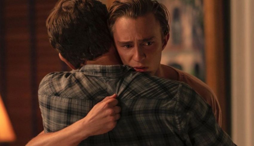 Two men hugging each other in a room.