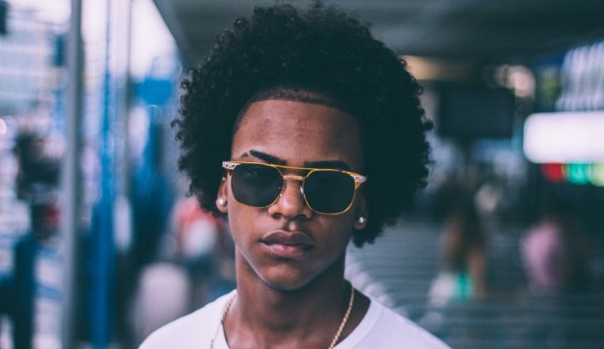 A young man with an afro wearing sunglasses.