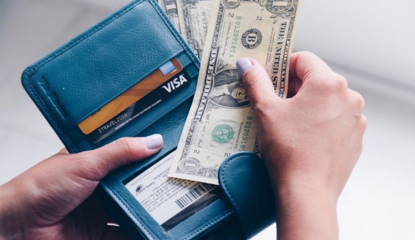 A woman is holding a wallet with money in it.
