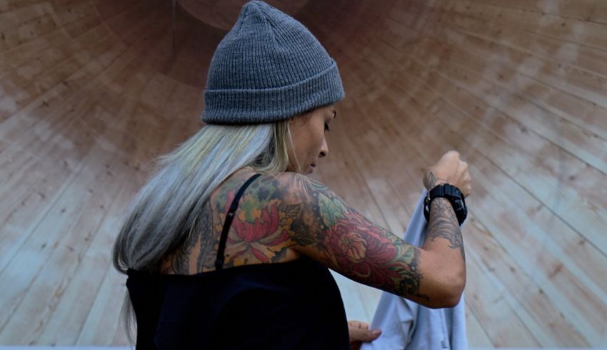A woman wearing a beanie in front of a wooden wall.