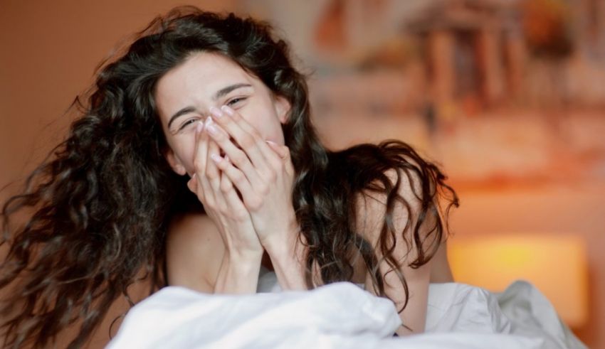 A woman sneezing in bed.