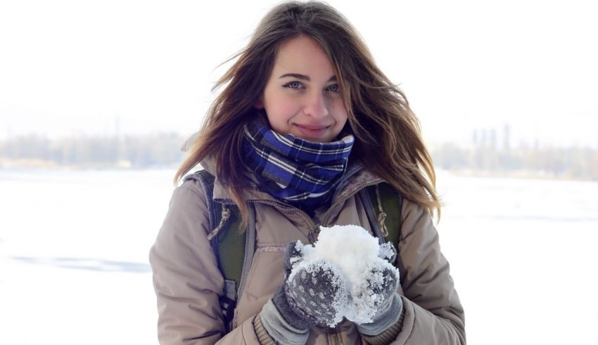 A woman holding a snowball in her hands.