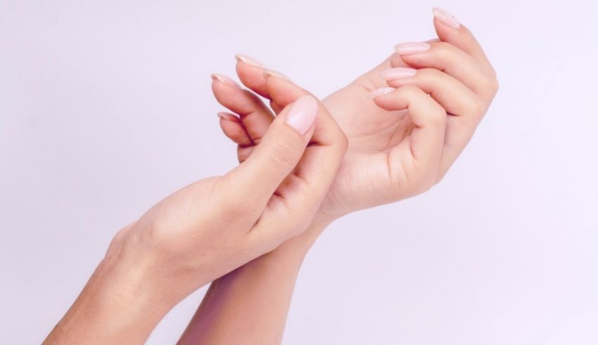 A woman's hands are touching each other on a white background.