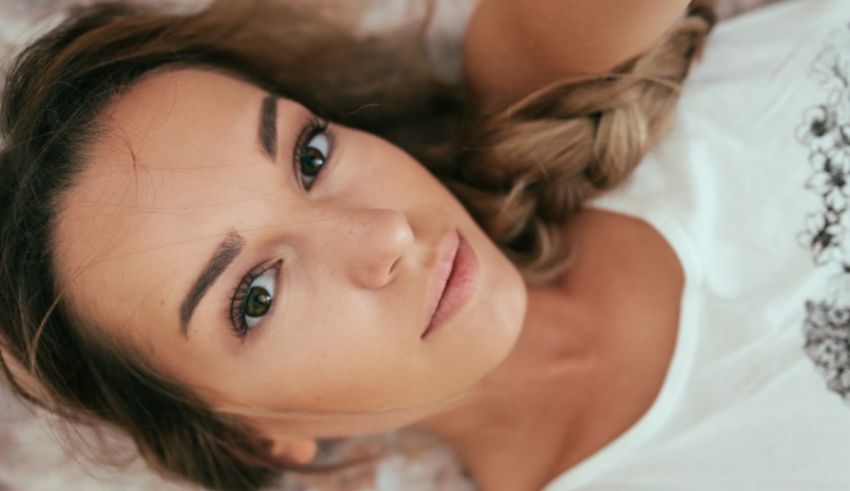 A woman laying on a bed with her eyes closed.