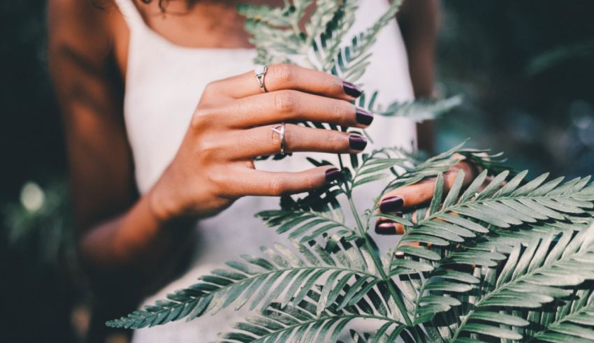 A woman is holding a plant in her hands.