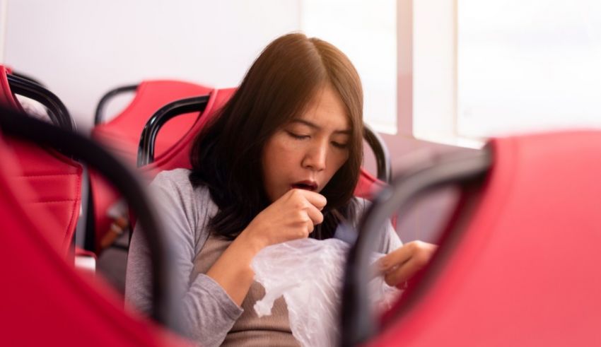 A woman is sitting on a bus with a tissue in her mouth.