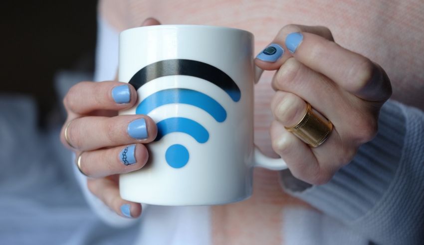 A woman holding a coffee mug with a wifi symbol on it.