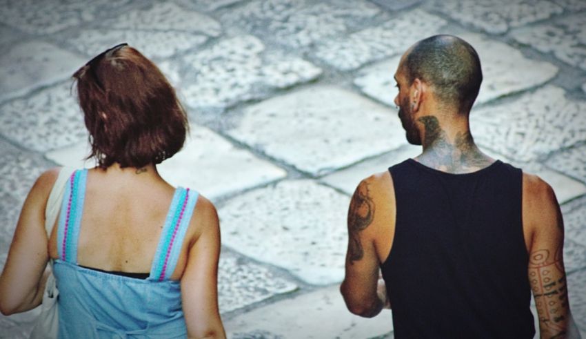A man and woman walking down a cobblestone street.