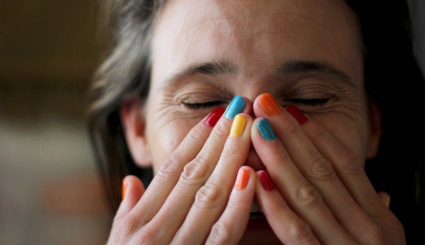 A woman covering her face with her hands.