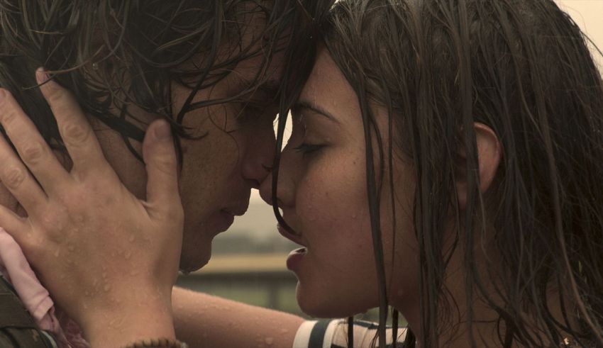 A man and woman kissing in the rain.