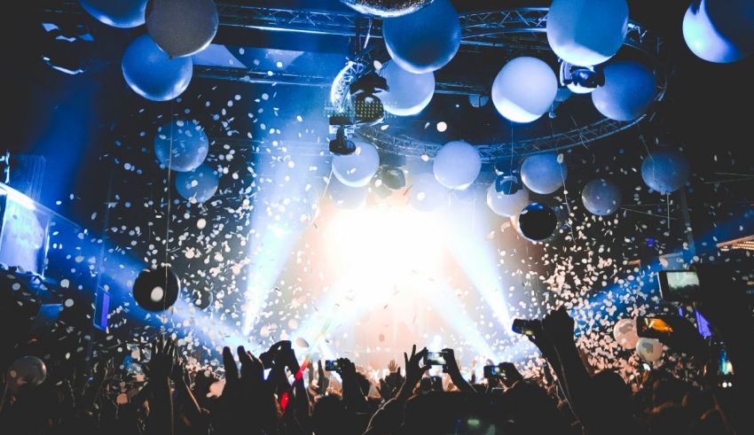 A crowd of people at a party with confetti and balloons.