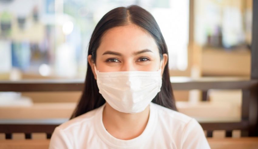 A woman wearing a surgical mask in a restaurant.