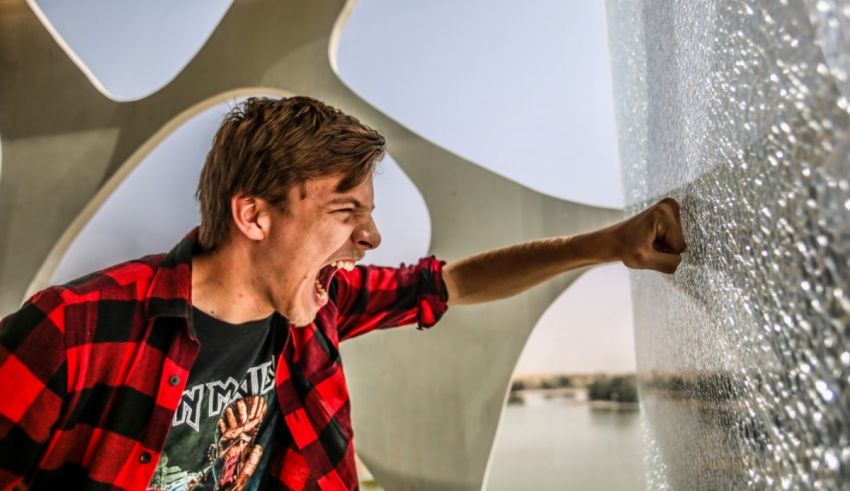 A young man yelling at a water wall.