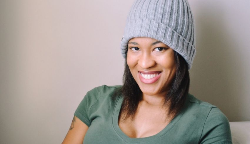 A woman wearing a gray beanie and smiling.