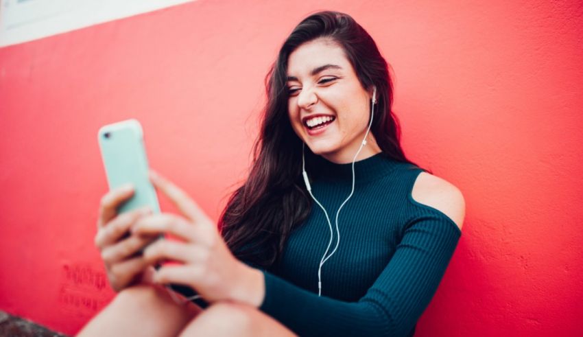 A young woman listening to music on her cell phone.