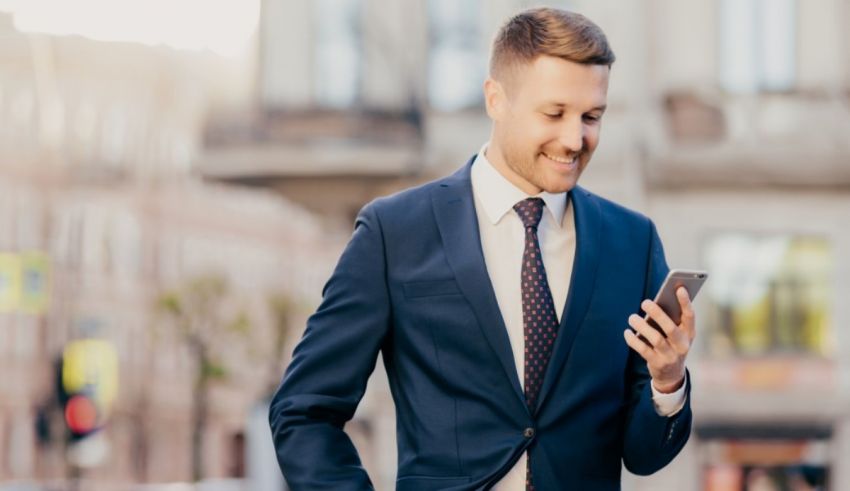 A businessman in a suit is using his cell phone.