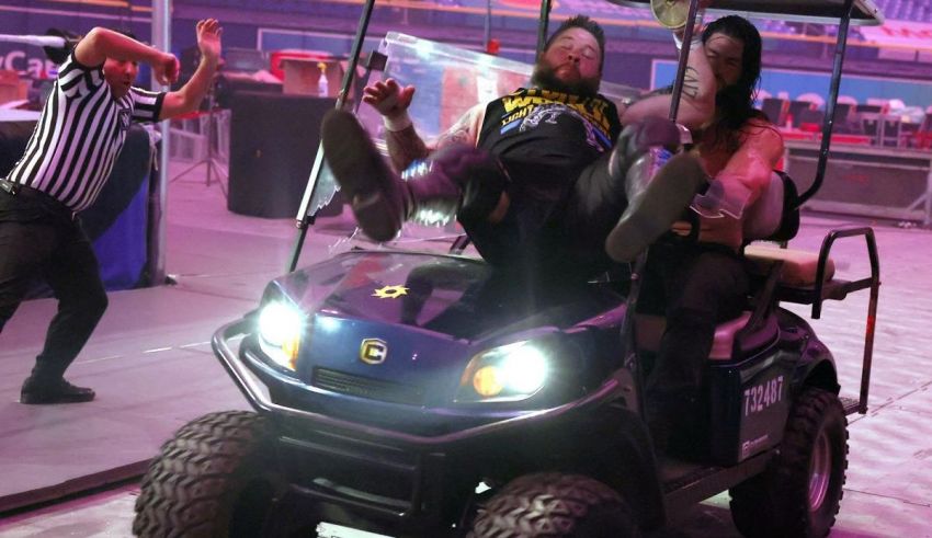 A group of people riding a golf cart in a wrestling ring.