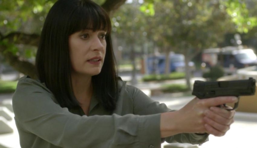 A woman holding a gun in a park.