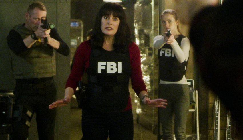 A woman in a fbi uniform is standing in front of a group of people.