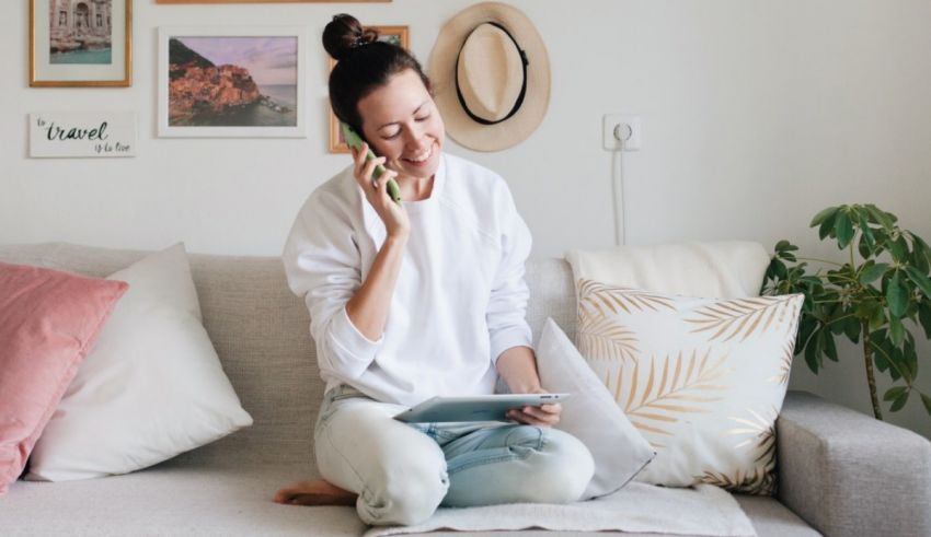 A woman sitting on a couch and talking on the phone.