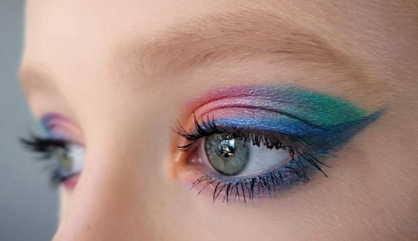 A close up of a girl's eye with colorful makeup.