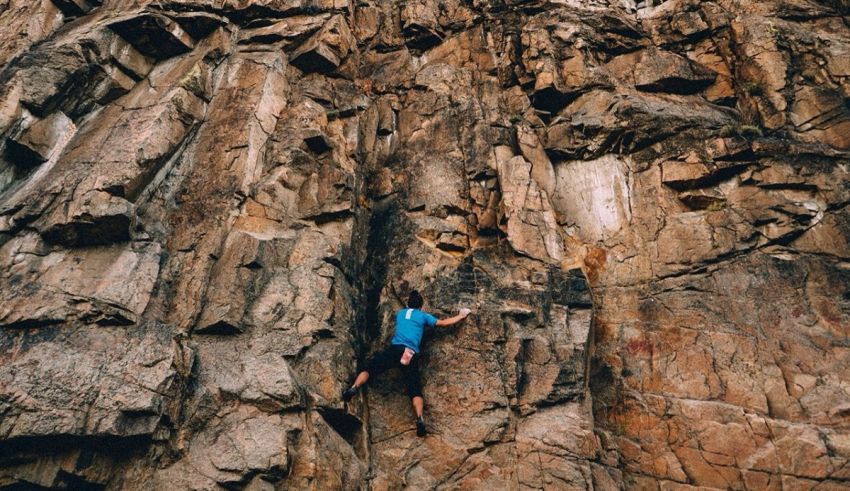 A person climbing up a rock face.