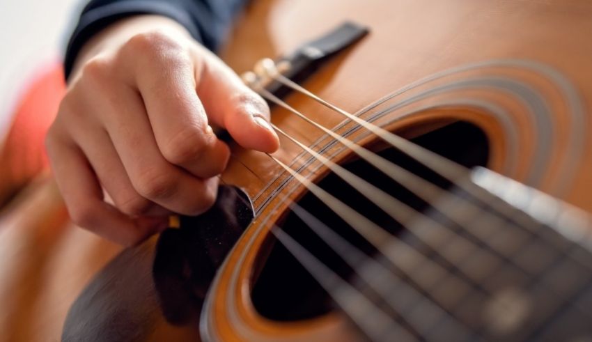 A close up of a person playing an acoustic guitar.